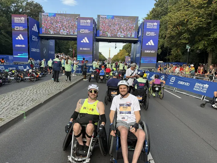 Thomas and a fellow wheelchair racer in the Berlin Marathon start area, under the start gantry