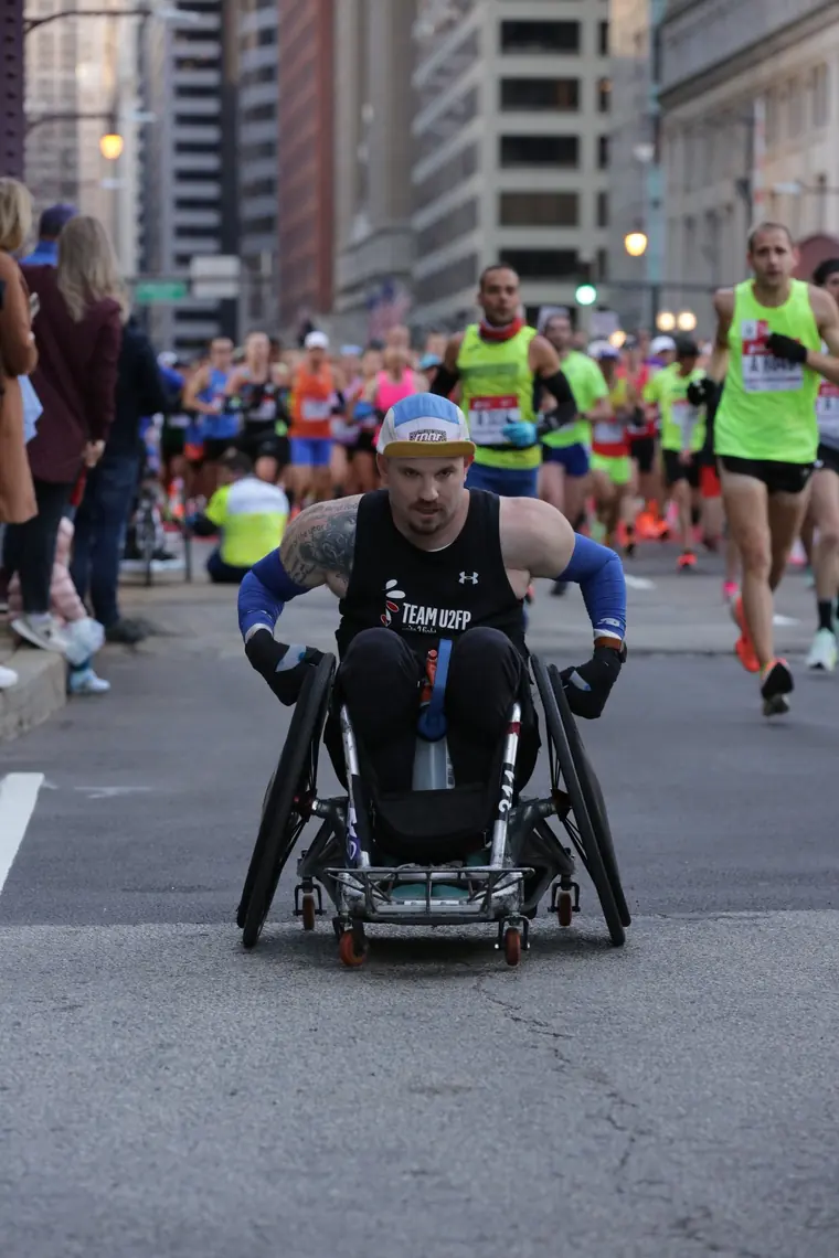 Thomas racing through a downtown Chicago intersection with runners alongside